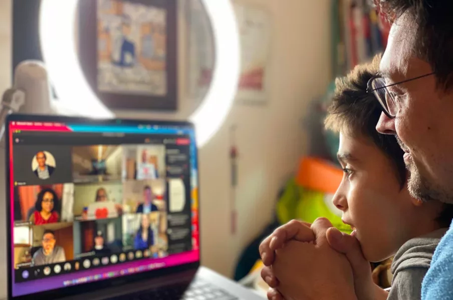 A man and a child watching a video on a laptop.