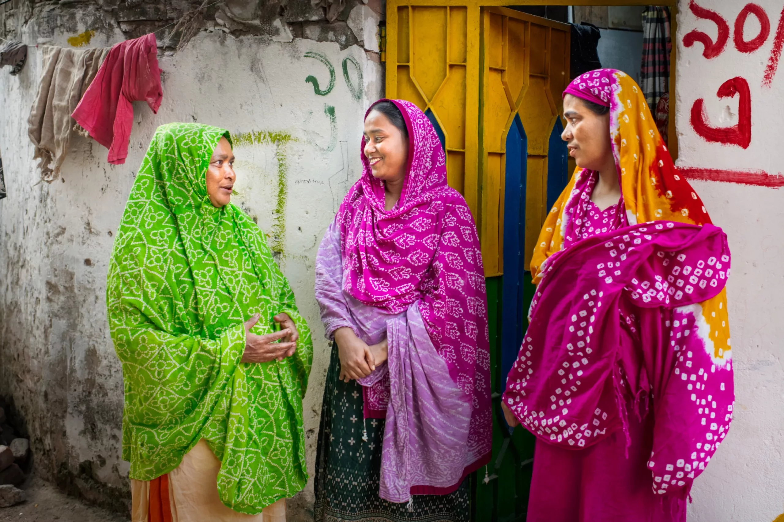 Ruma Akter socializes outside with two of her female trainees.