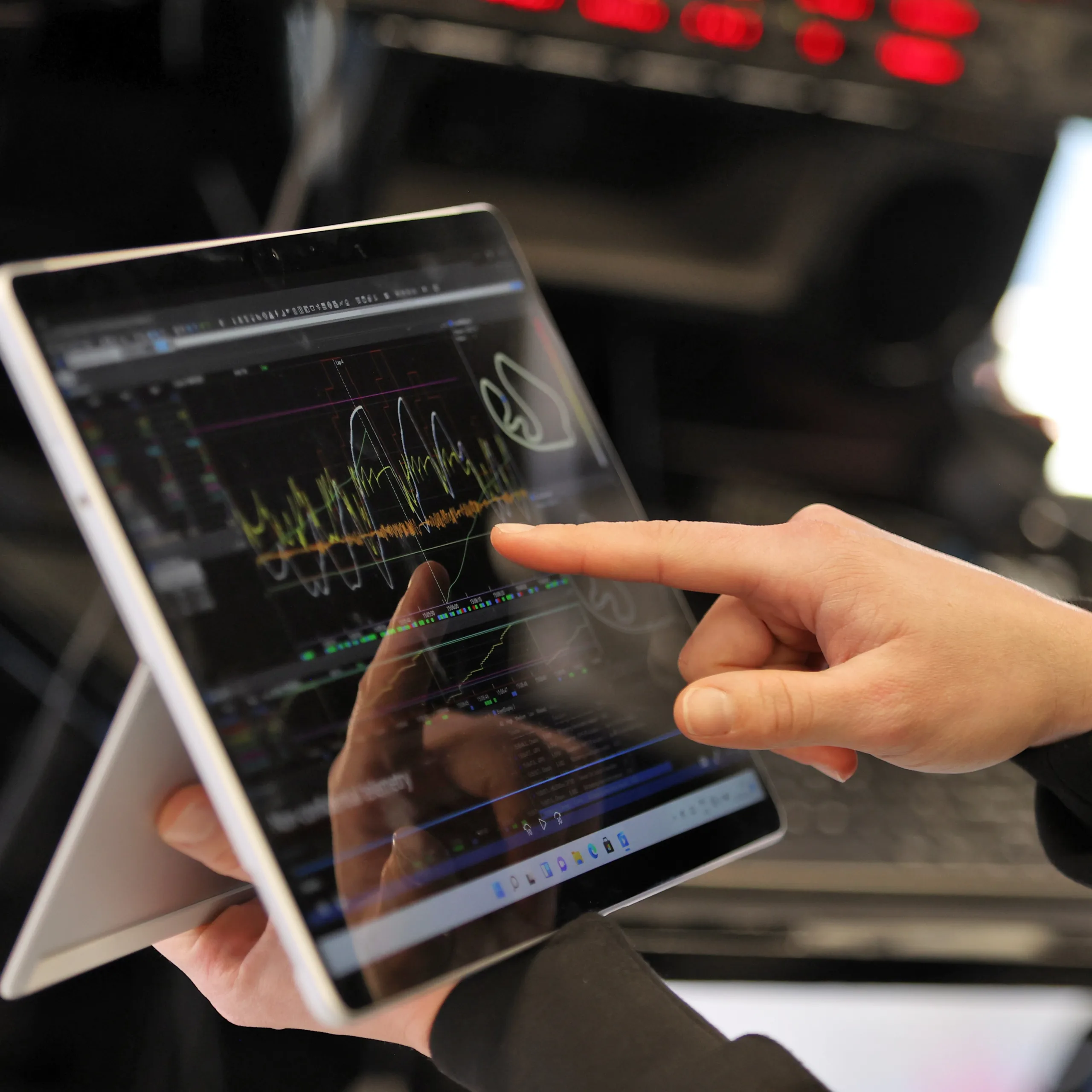 Finger pointing toward Microsoft Surface device with Power BI data