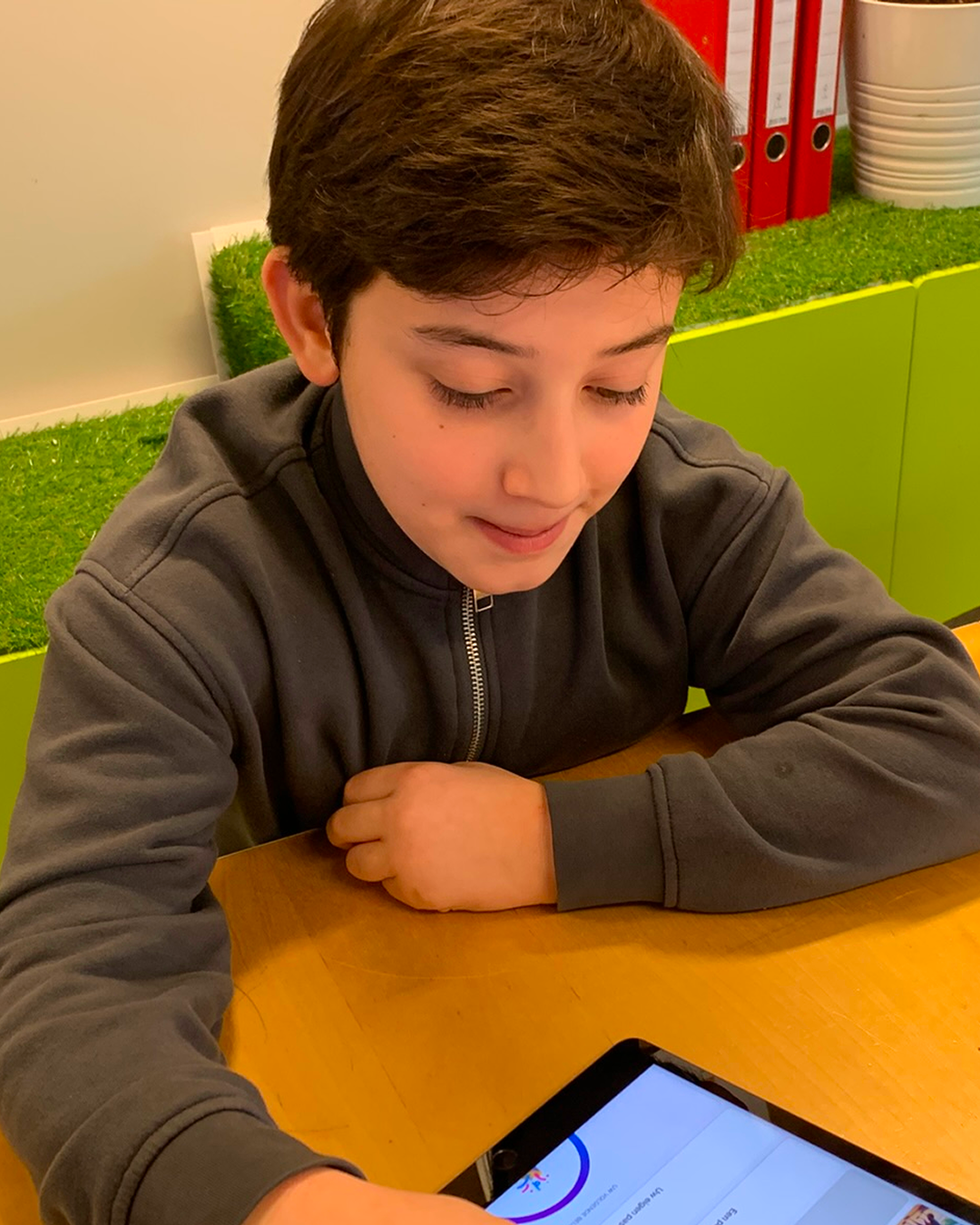 Boy in black sweater using a tablet