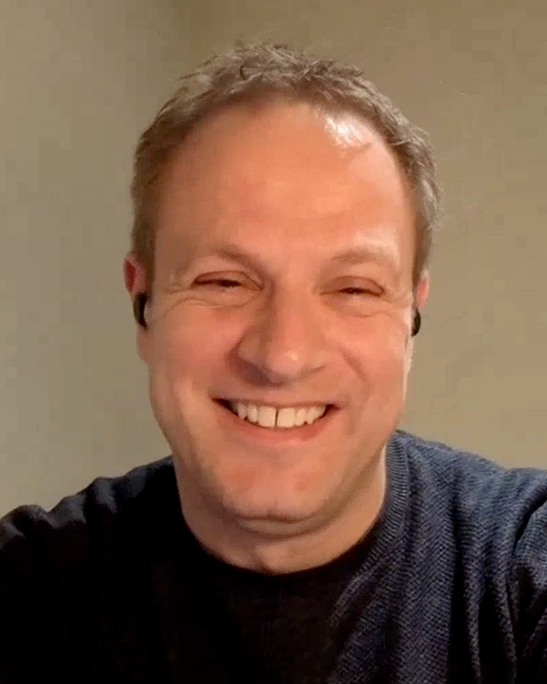 Man smiling wearing a dark blue shirt