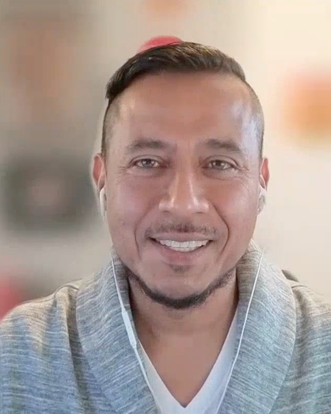 Man smiling wearing a gray sweater
