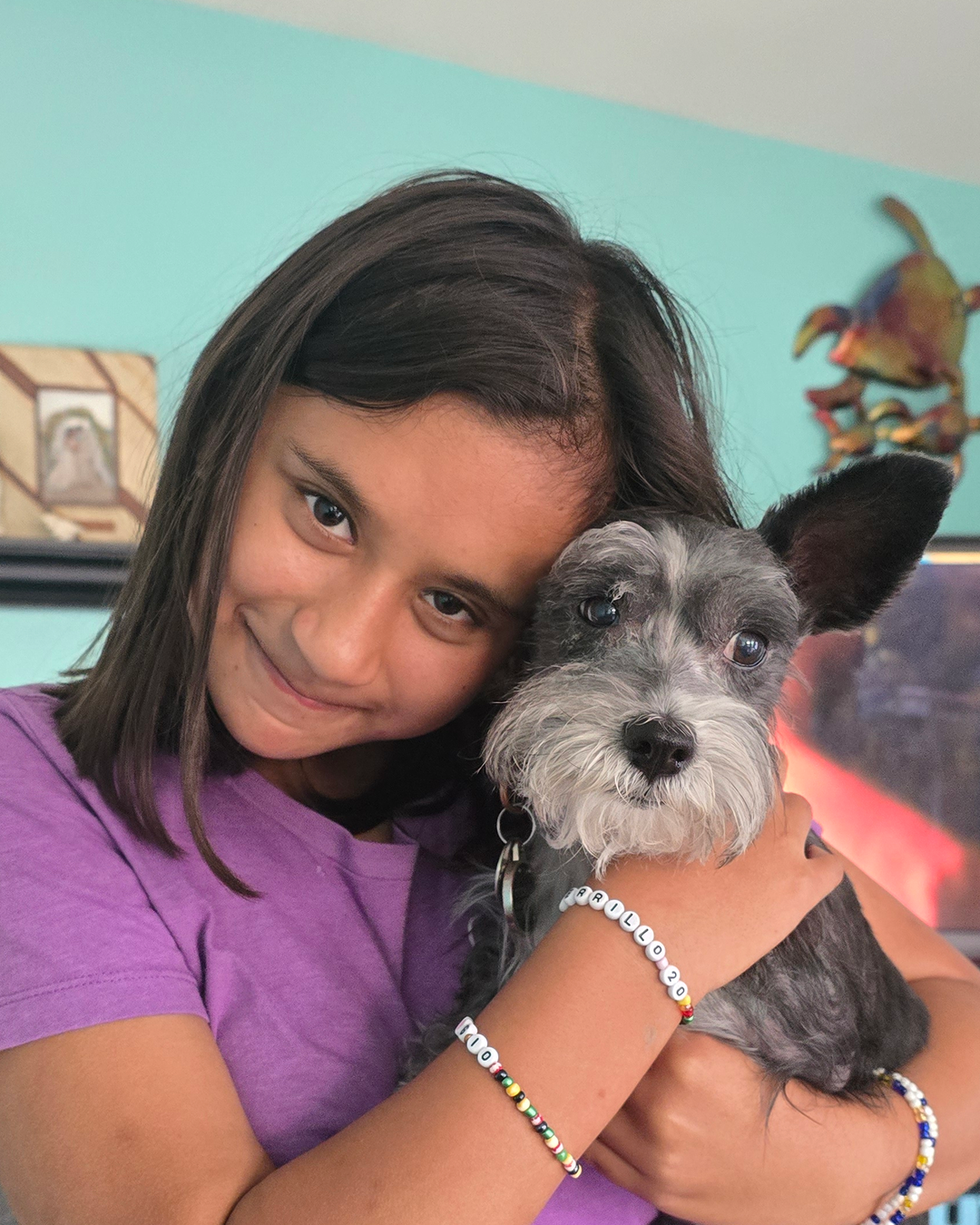 Girl smiling while holding a schnauzer dog