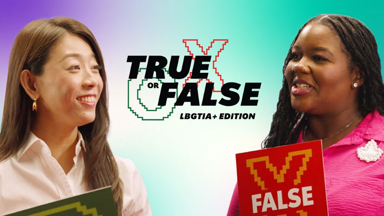 Two women holding "True" and "False" signs stand in front of a colorful background with the text “True or False LGBTIQA+ Edition” between them.